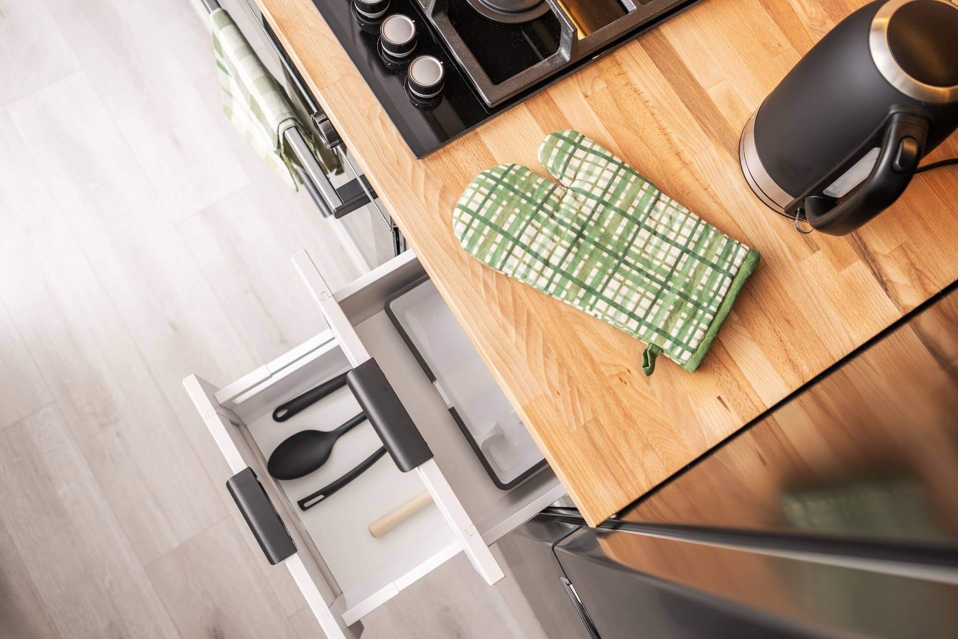 En öppen kökslåda med köksredskap, som visar funktionaliteten i ett kök efter en lyckad köksrenovering.